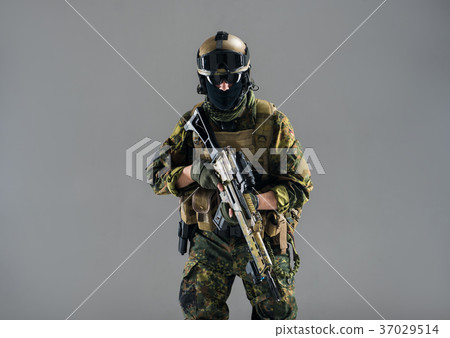 Serious man keeping assault rifle in hand 37029514