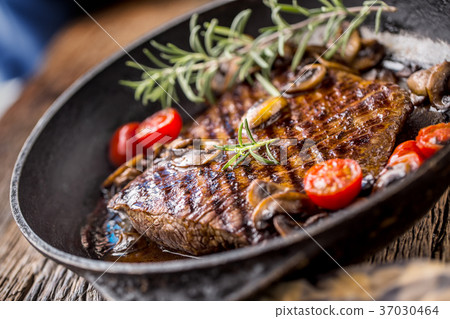 Grill beef flank steak with rosemary and musrooms. Grill beef flank steak with rosemary and musrooms. 37030464