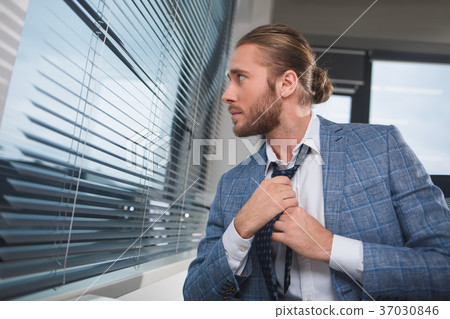 Good looking guy straightening a tie Good looking guy straightening a tie 37030846