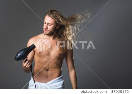 Serious man drying rainy locks Serious man drying rainy locks 37030875