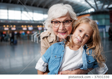 Optimistic elderly lady is posing at terminal with Optimistic elderly lady is posing at terminal with 37031330