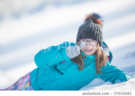 Happy young Pre-Teen girl in warm clothingin snow. 37033081