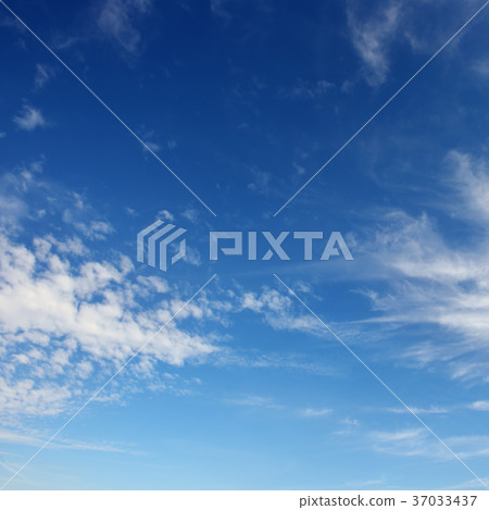 White cirrus clouds against the dark blue sky. 37033437