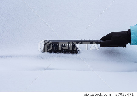 Woman cleaning snow from the car 37033471