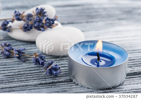Lavender flowers, blue lit candle Lavender flowers, blue lit candle 37034287