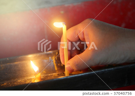 Lighted candle and incense for Buddha.  37040756