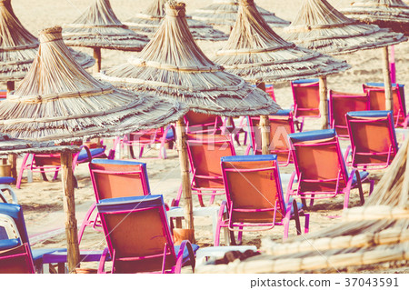 Beach loungers and umbrellas on the sea.  37043591