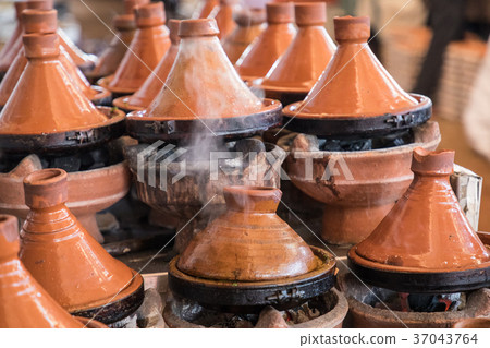 Preparing food in tajin traditional dish, Morocco 37043764