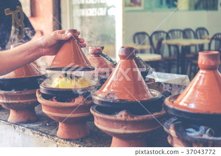 Preparing food in tajin traditional dish, Morocco Preparing food in tajin traditional dish, Morocco 37043772