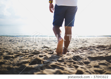 young man walking on the beach. young man walking on the beach. 37043822