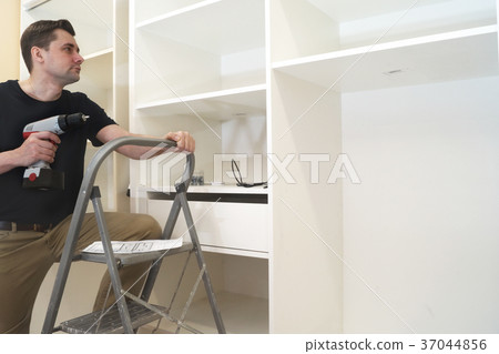 Cabinet master installing new built-in wardrobe. 37044856