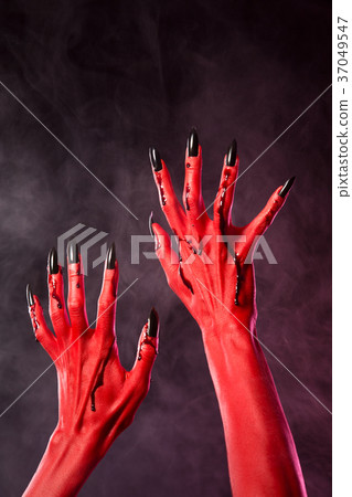 Red devil hands with black nails covered in blood 37049547