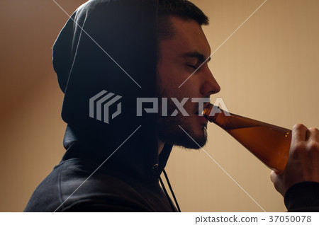 Sad depressed young man drinking beer Sad depressed young man drinking beer 37050078