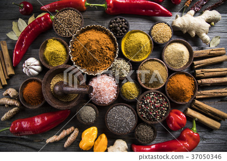 A selection of various colorful spices on a wooden A selection of various colorful spices on a wooden 37050346