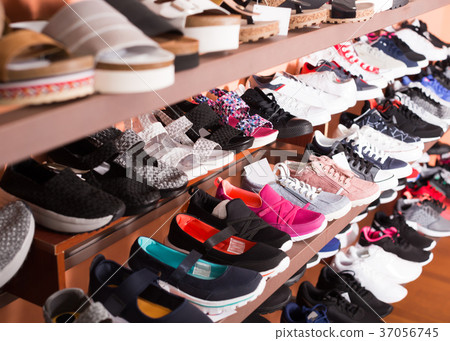 Stylish shoes are standing on shelves 37056745
