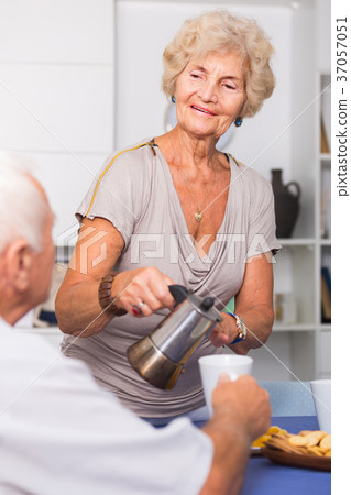 Happy senior woman pouring tea Happy senior woman pouring tea 37057051