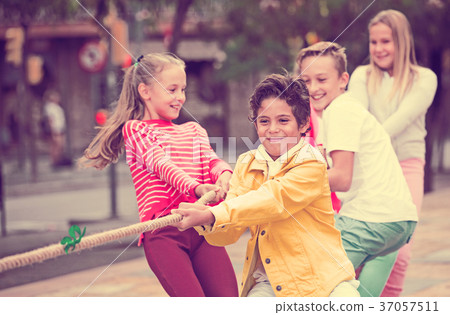 Company of kids are playing in tug of war Company of kids are playing in tug of war 37057511