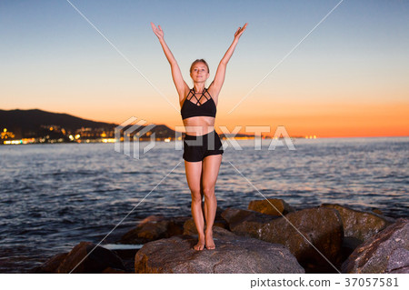 Female 24-31 years old is practicing stretching Female 24-31 years old is practicing stretching 37057581
