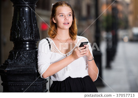 female messaging on phone at the street 37057713