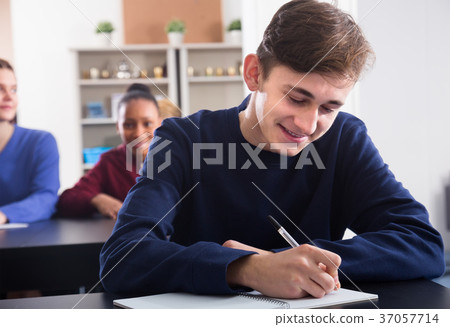 young male and female students following explanations of teacher young male and female students following explanations of teacher 37057714