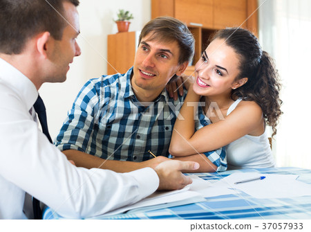 Insurance agent and couple indoors. Insurance agent and couple indoors. 37057933