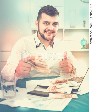 Young male businessman earning money easily online in Internet Young male businessman earning money easily online in Internet 37057954