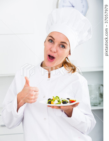 Girl cook shows plate of salad 37057979