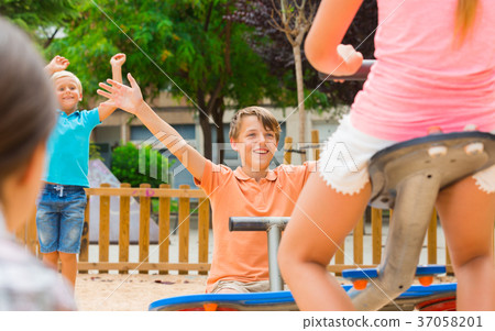 Cheerful children are teetering on the swing 37058201