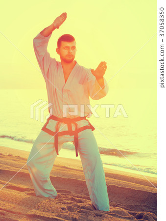Man doing karate at ocean Man doing karate at ocean 37058350