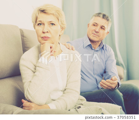 upset middle-aged couple quarreling at home with each other 37058351