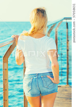 Cheerful female is posing playfully on pirce in her free time Cheerful female is posing playfully on pirce in her free time 37058631