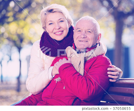 Mature couple sitting in park Mature couple sitting in park 37058655