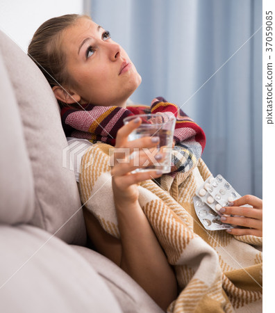 Unhealthy female is sitting in a plaid with medications 37059085