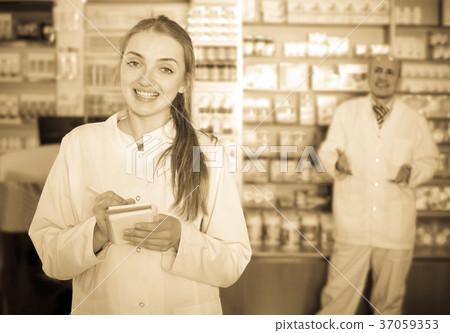 Pharmacist and assistant working at farmacy reception 37059353