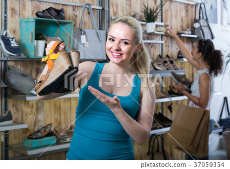 girl showing a chosen pair of shoes 37059354