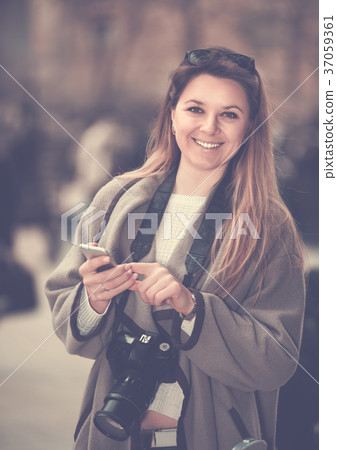 Girl holding phone in hands and looking up her way using app, gps Girl holding phone in hands and looking up her way using app, gps 37059361