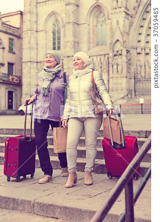 Senior females walking with baggage on city Senior females walking with baggage on city 37059485