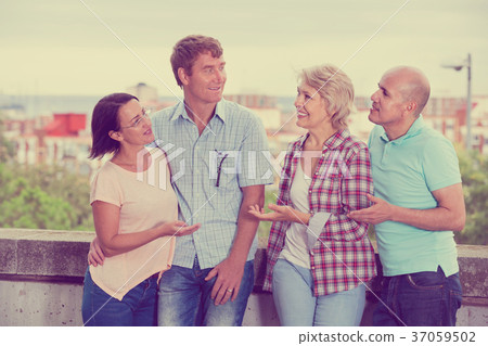 Portrait of mature cheerful males and females talking outdoors Portrait of mature cheerful males and females talking outdoors 37059502
