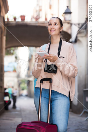 Brunette woman looking for the map in the phone 37060193