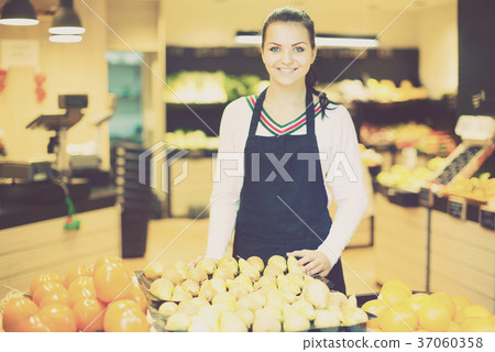 Assistant displaying fruits of grocery store 37060358
