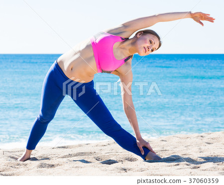 Positive female stretching muscles on the sand Positive female stretching muscles on the sand 37060359