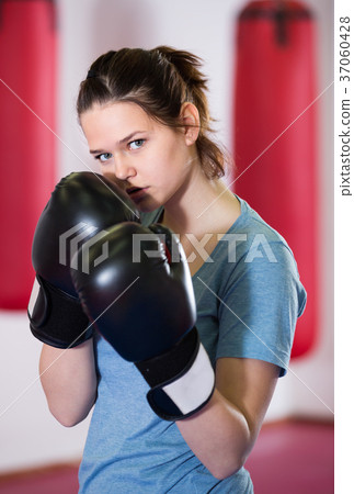serious sportwoman in the boxing hall practicing boxing punches 37060428
