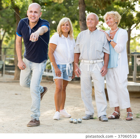 Group of friendly mature men and women playing petanque Group of friendly mature men and women playing petanque 37060510