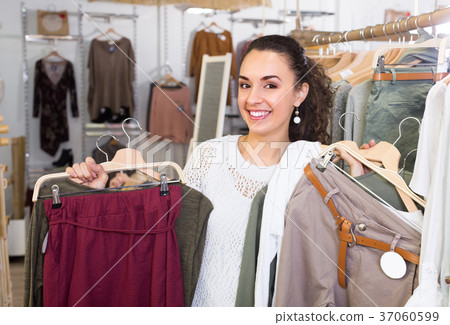 Girl selecting new garments at the store . Girl selecting new garments at the store . 37060599