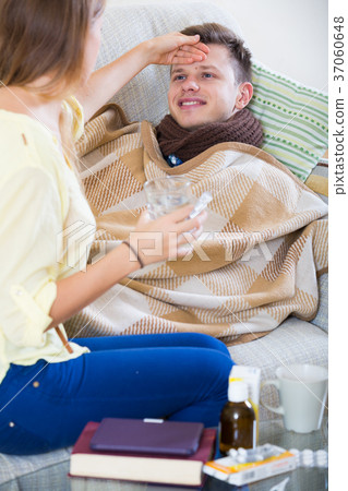 Wife touching husband forehead to check fever Wife touching husband forehead to check fever 37060648