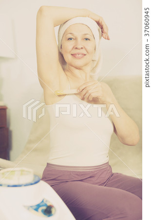 Woman doing body hair removal 37060945