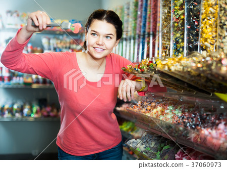 Girl studying assortment of marmalade and bonbons Girl studying assortment of marmalade and bonbons 37060973