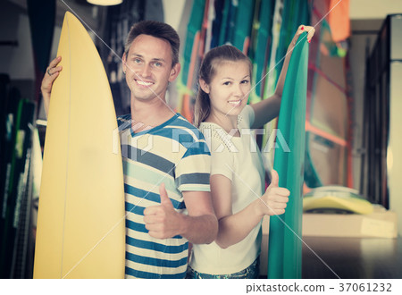 Portrait of happy couple standing with new surfboards 37061232