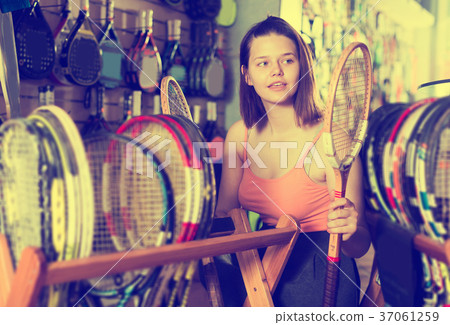 Female teen choosing wood racket for squash 37061259