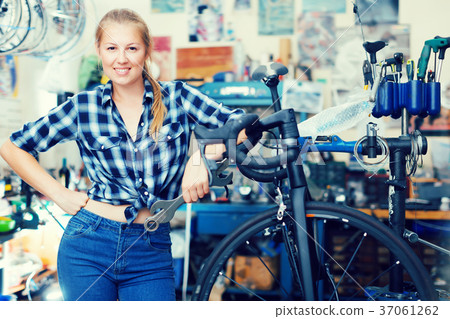 Portrait of adult girl who is fixing her bicycle Portrait of adult girl who is fixing her bicycle 37061262